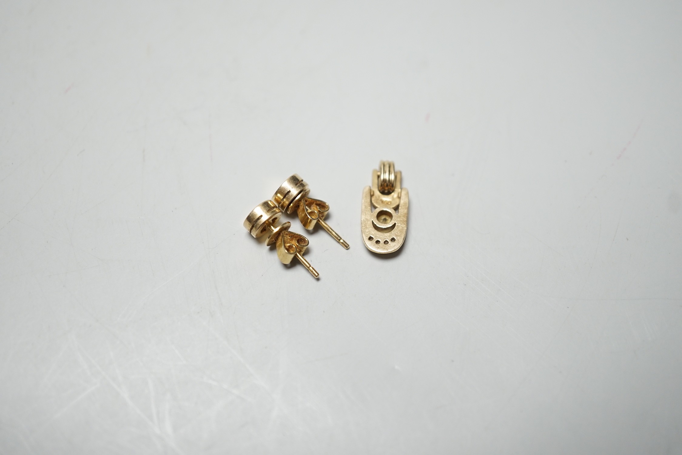 A modern pair of 585 yellow metal and solitaire diamond set ear studs, 6mm and a matching pendant, gross weight 3.9 grams.